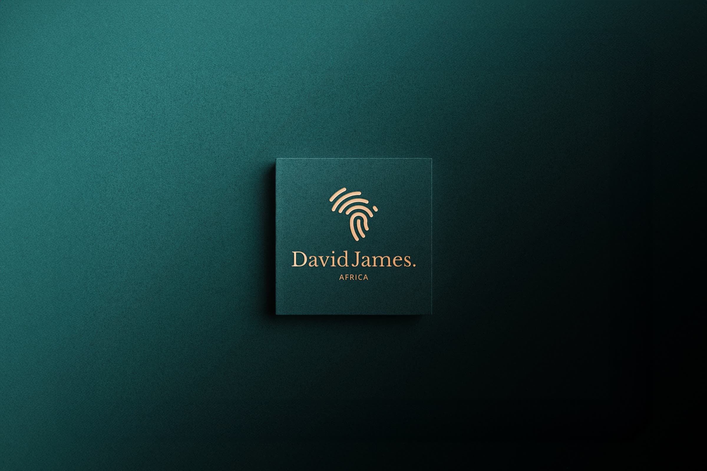 The finished mark embossed in gold on a deep teal card