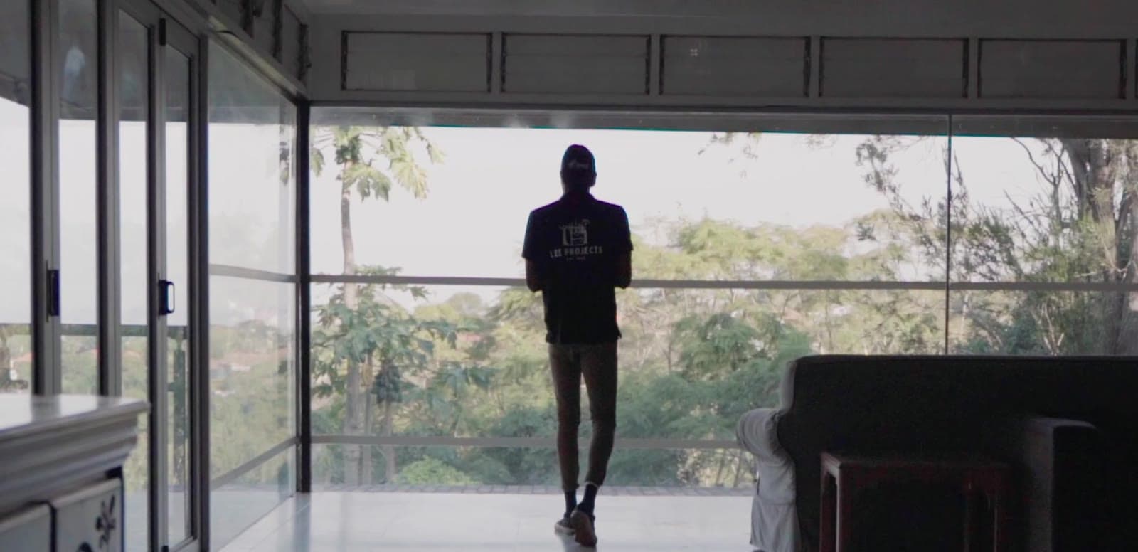 A silhouette in a glass-walled room looking out